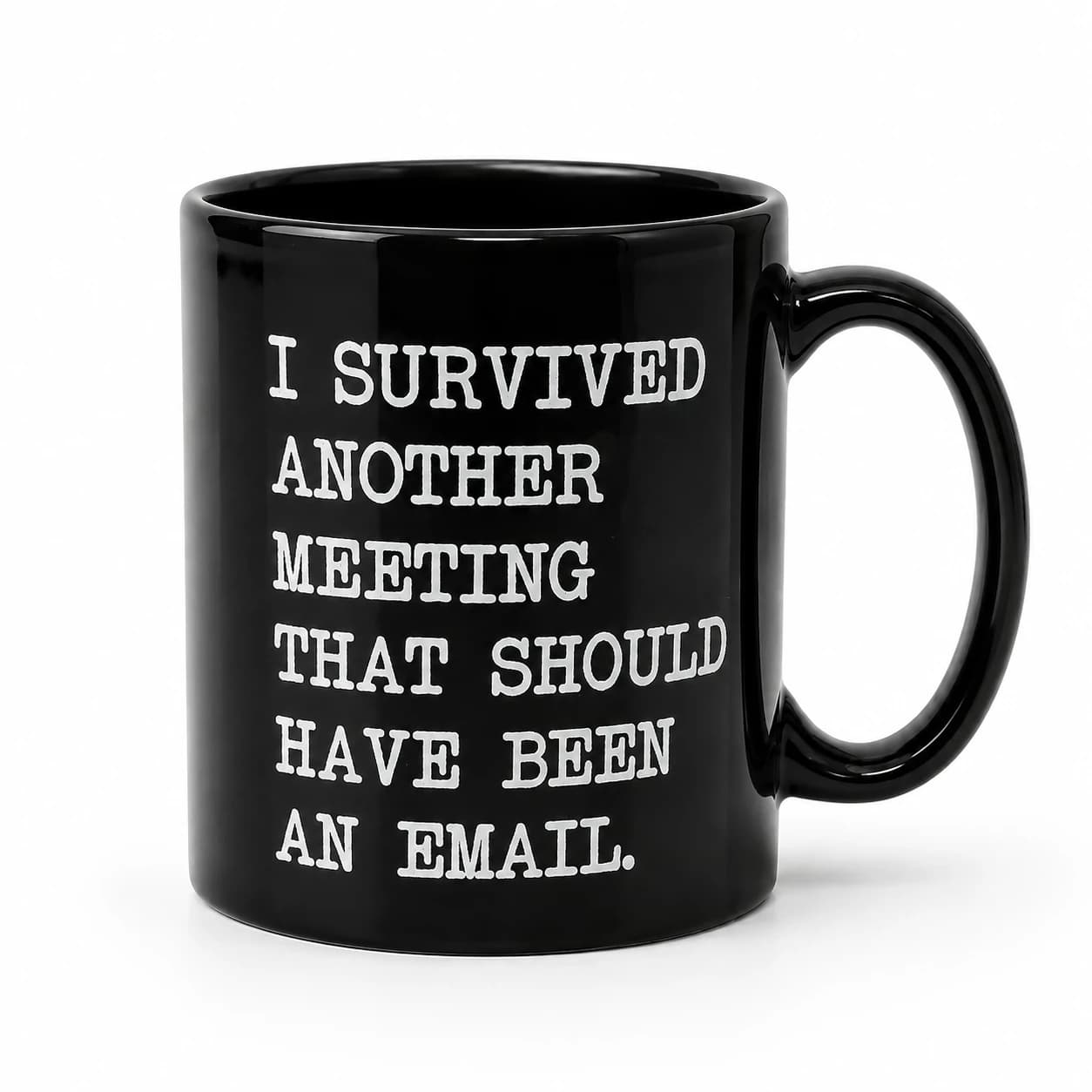 Angled studio view of the black ceramic I Survived Another Meeting mug with its full white slogan